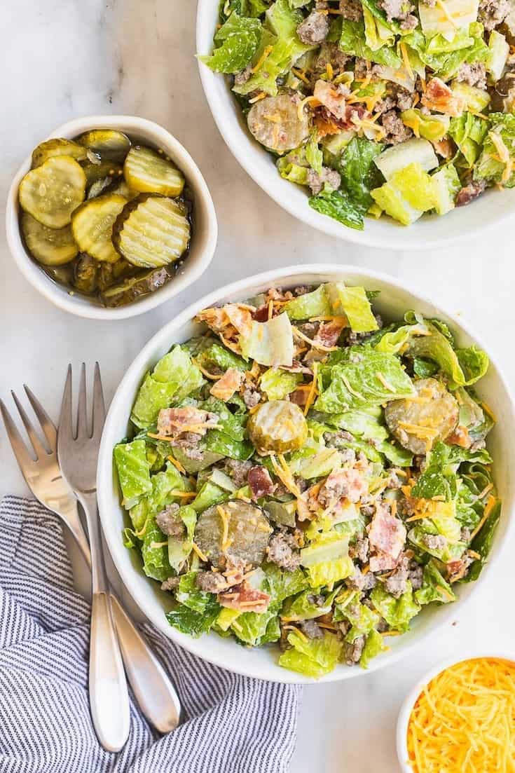 Keto Bacon Cheeseburger Salad Recipe in a bowl with pickles and a fork