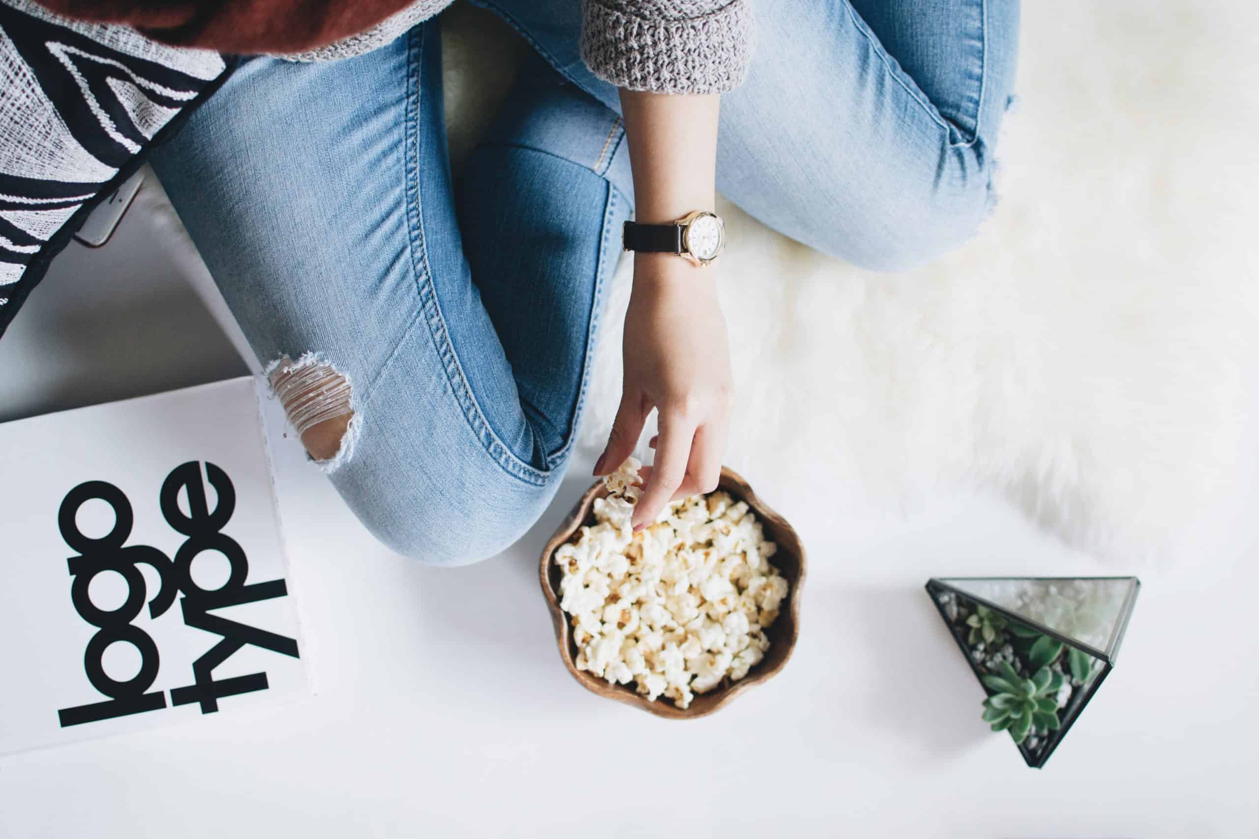 woman sitting with a bowl of popcorn