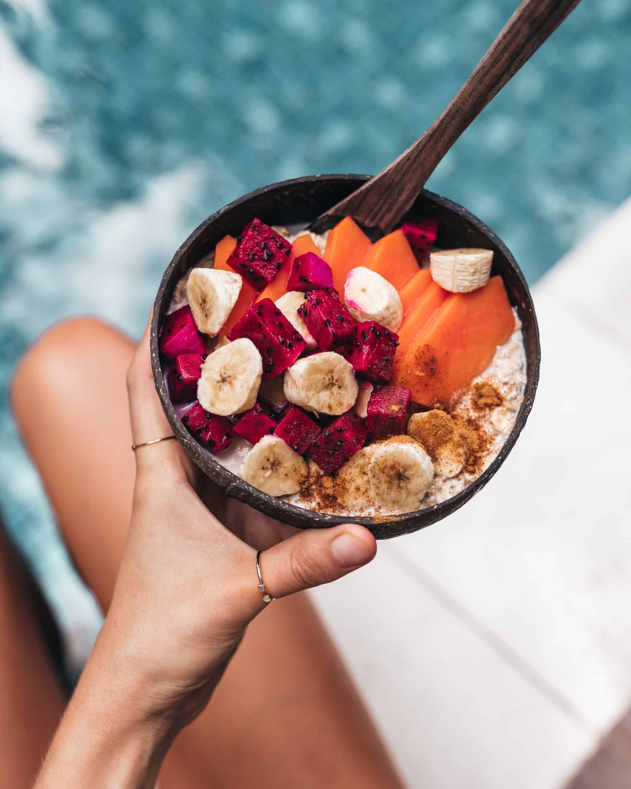 woman holding a plant based oatmeal bowl