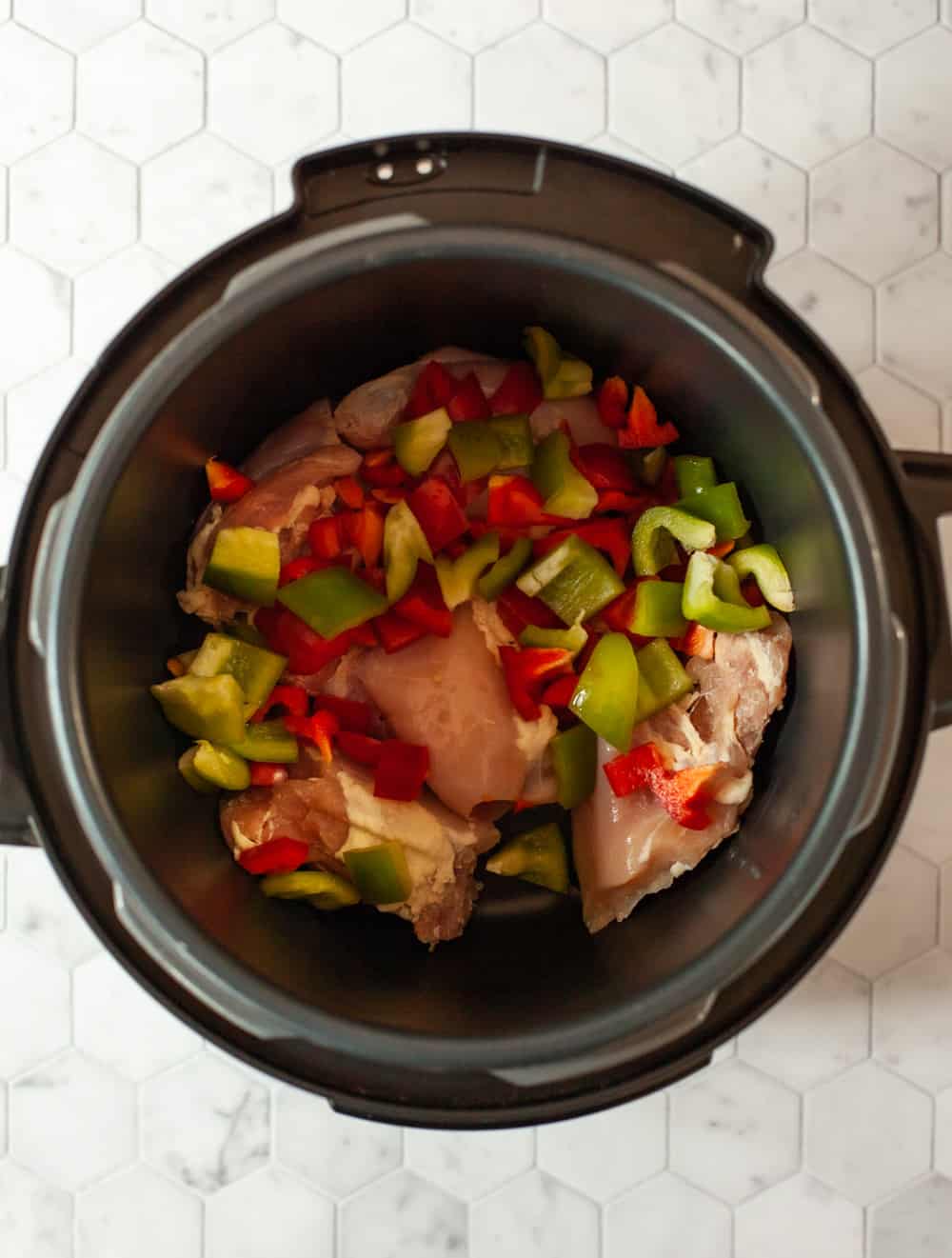 overhead photo of chicken and vegetables in a pressure cooker