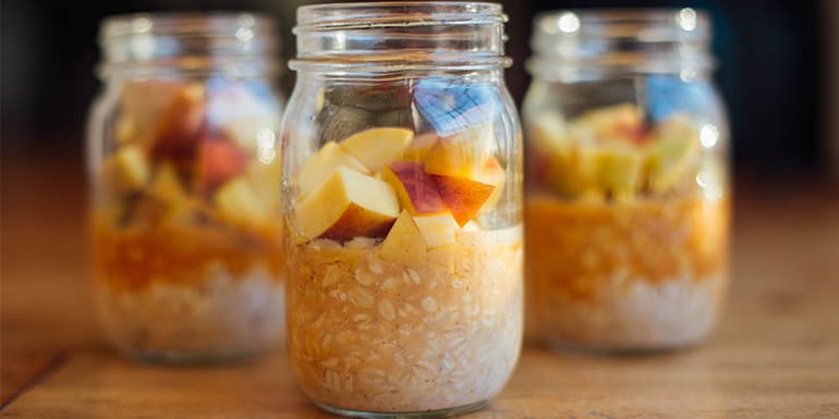 Vanilla Shakeology, Diced Peaches, and Oatmeal in 3 mason jars