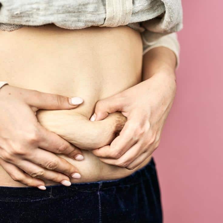 woman squishing her belly together