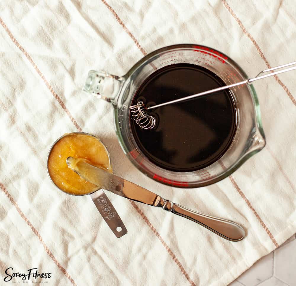 cup of thick raw honey next to elderberry extract