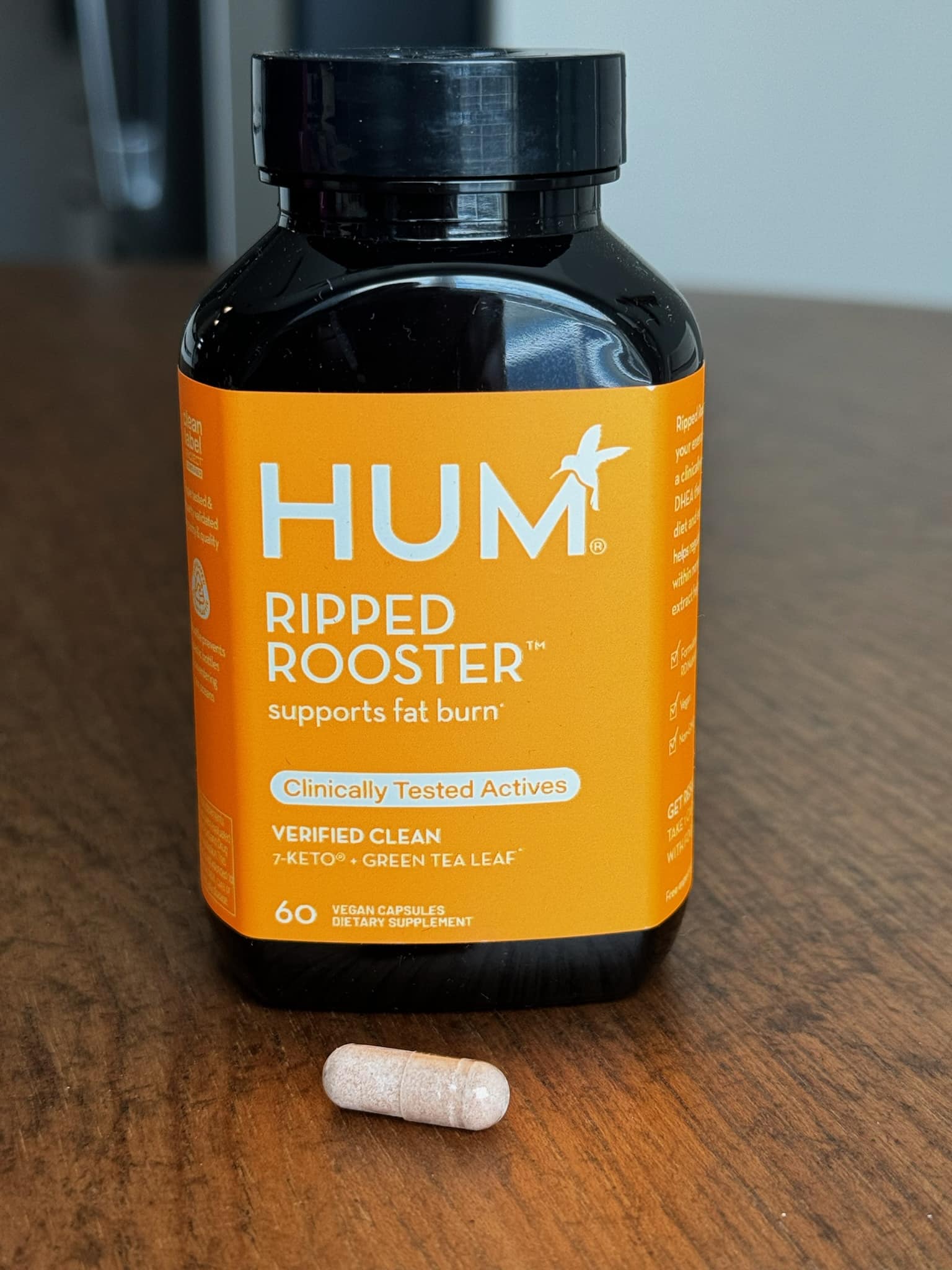 bottle of Hum Ripped Rooster and 1 capsule sitting out