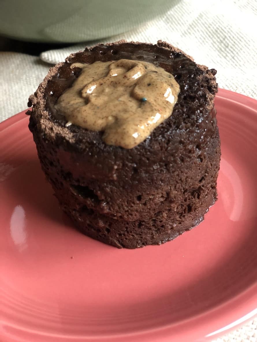 Shakeology mug cake on a plate with nut butter on top