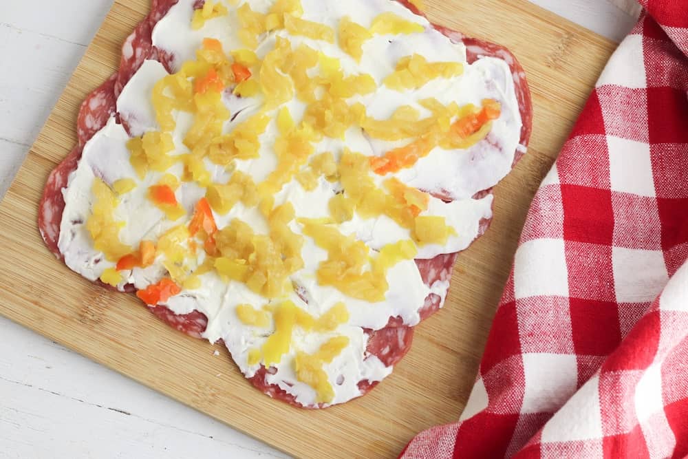 salami topped with cream cheese and banana peppers