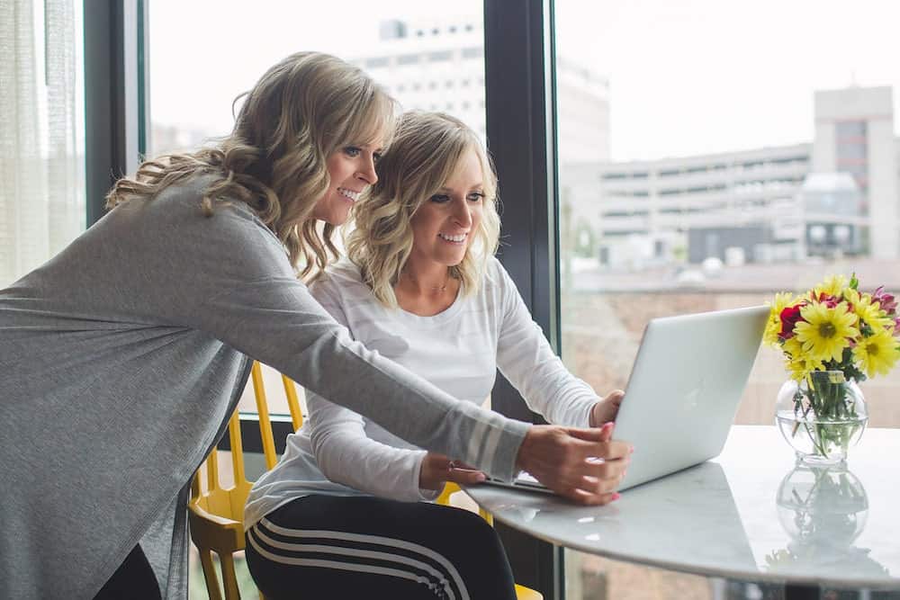 Kim and Kalee at a desk looking at a laptop