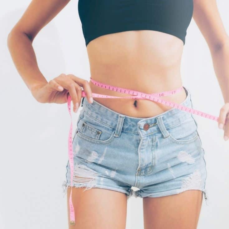 woman measuring her waist