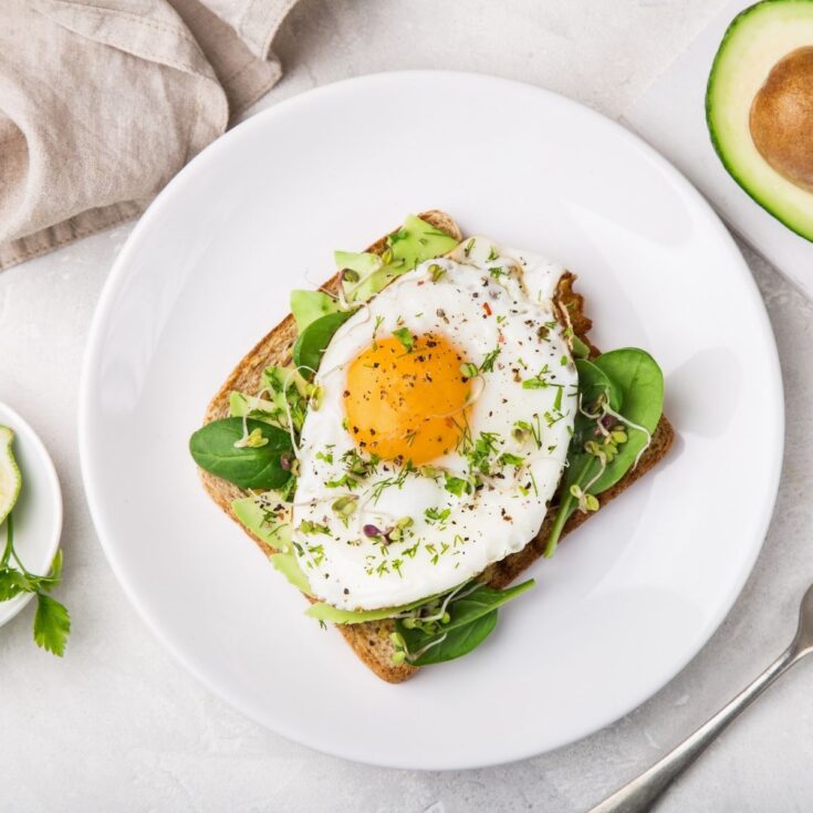 piece of avocado toast with an egg on top