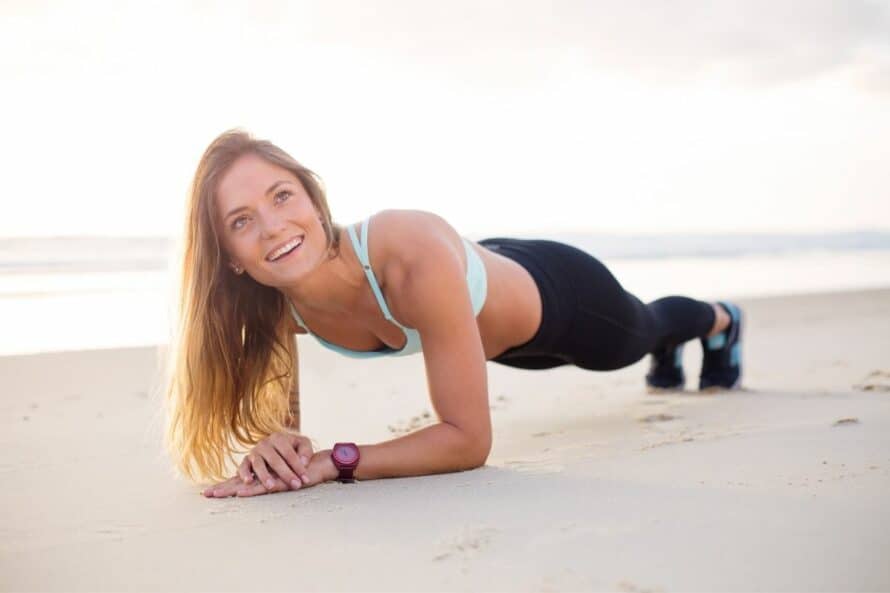 young woman during a plank on the beach
