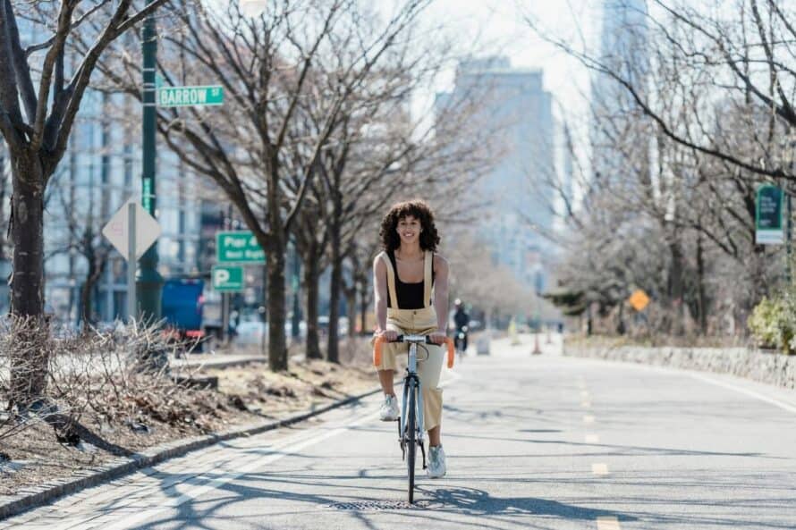 young woman on a road bike during the day in a large city
