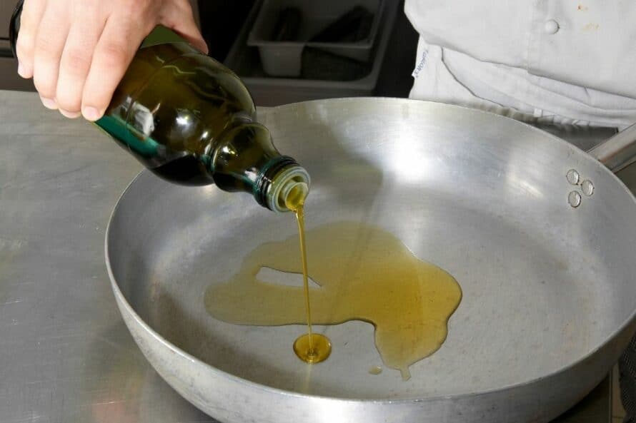 pouring oil into a skillet
