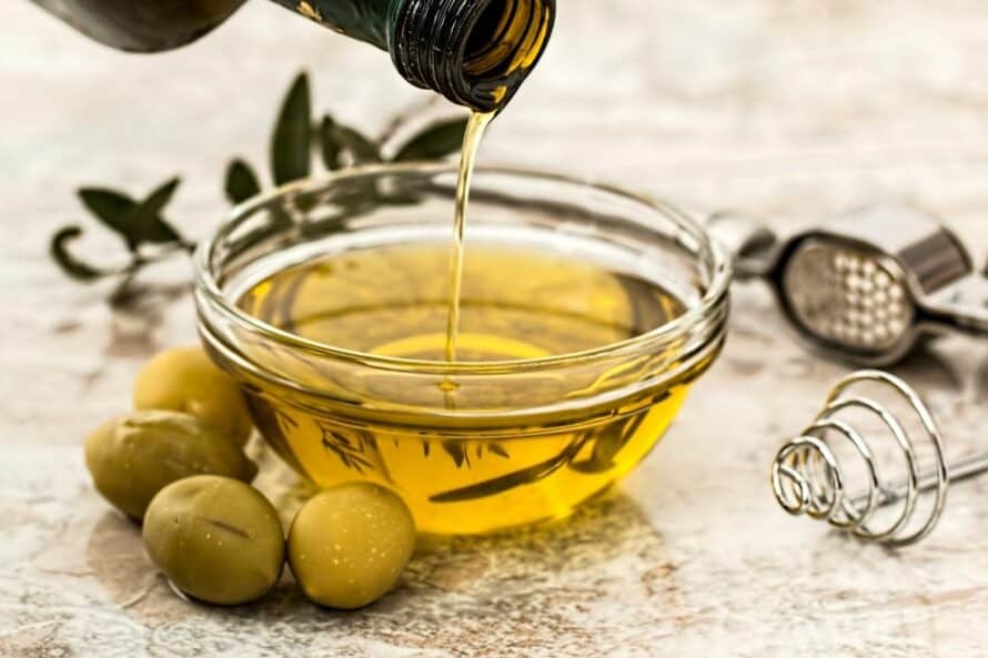 pouring extra virgin olive oil in a glass bowl