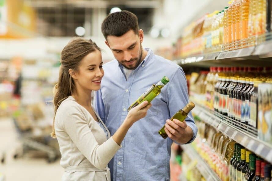 couple looking at olive oil in the grocery