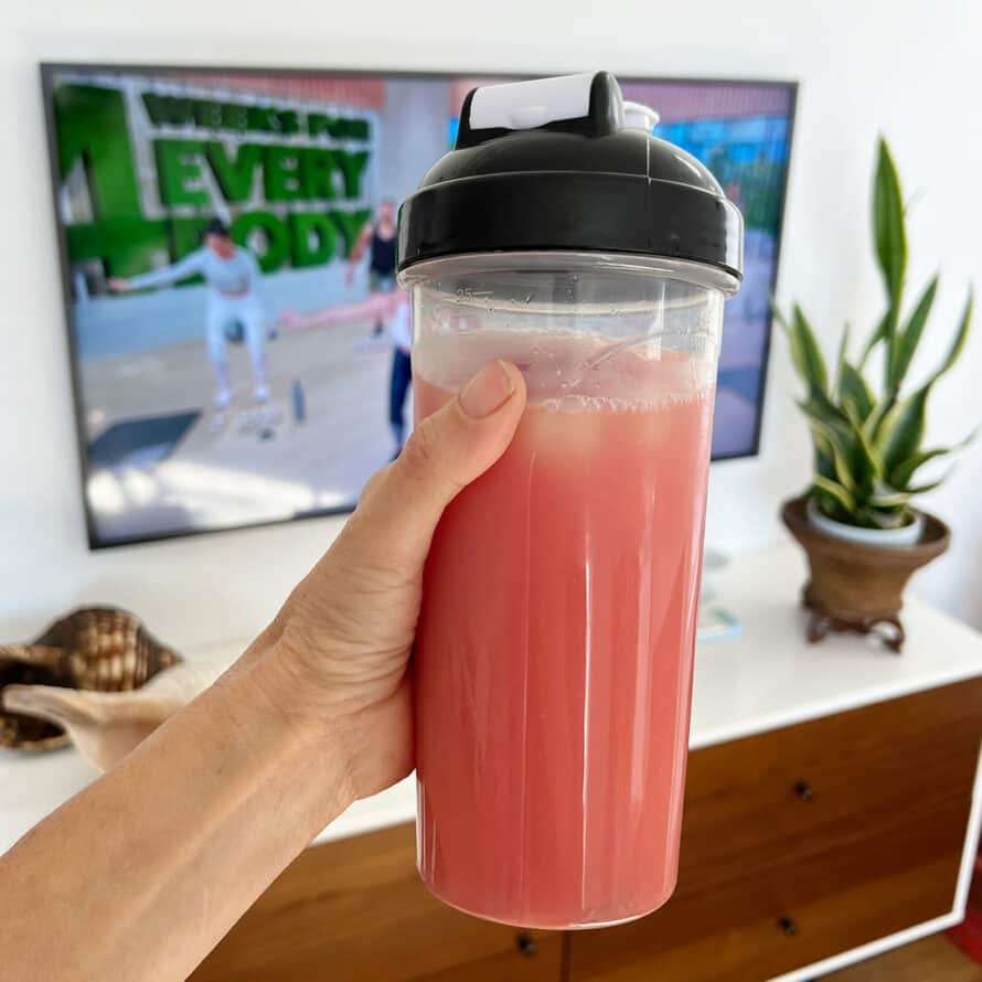 energize in a shaker cup in front of a tv with 4 Weeks for Every Body on It