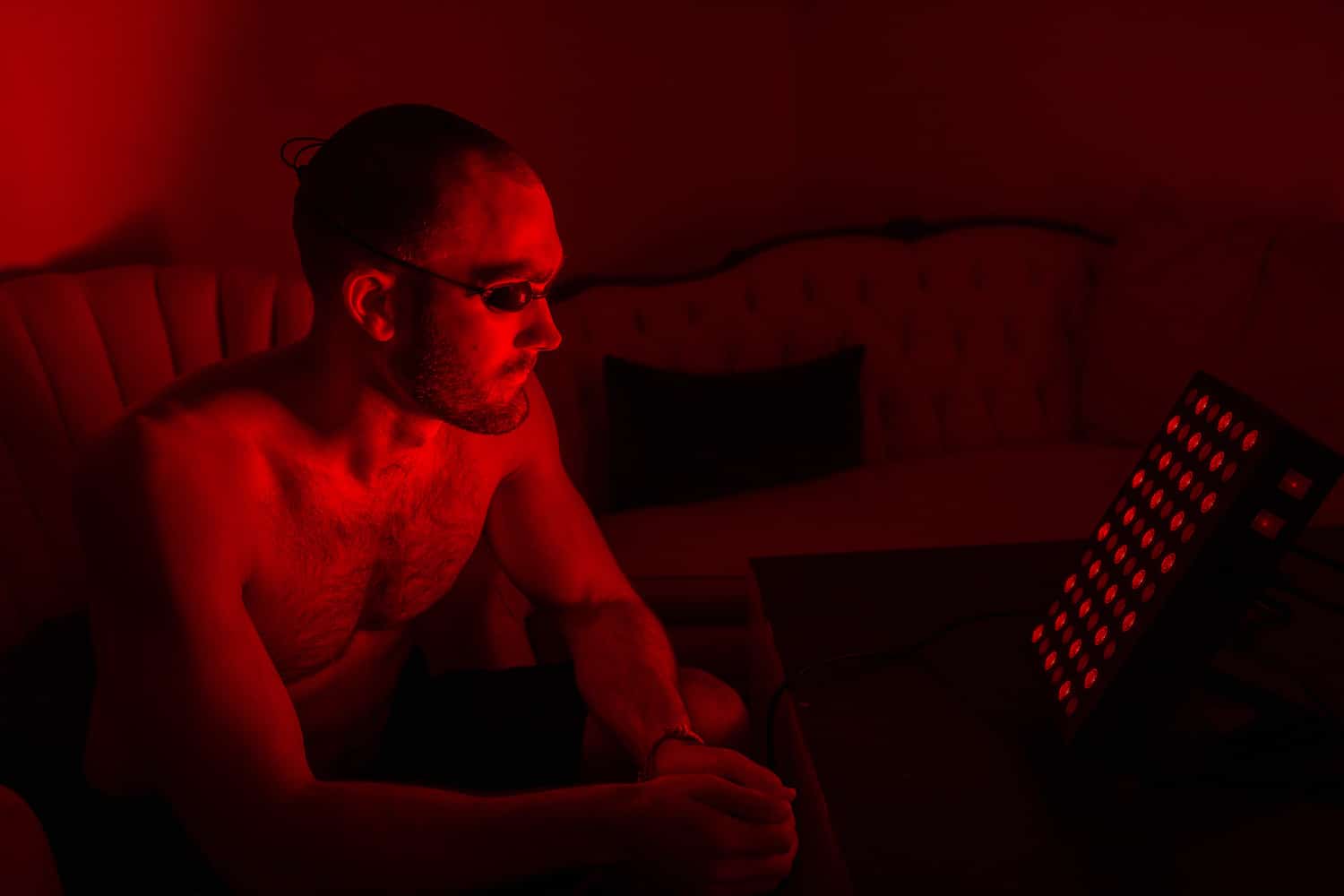 man using red light therapy