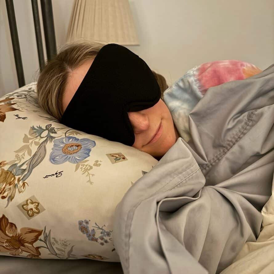 Kalee tucked into bed with a eye mask on