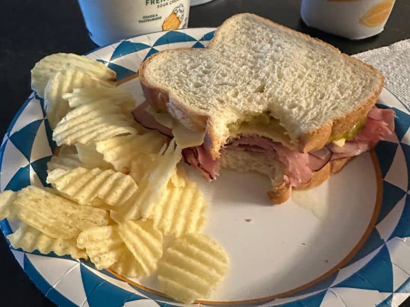 ham sandwich on white bread and chips