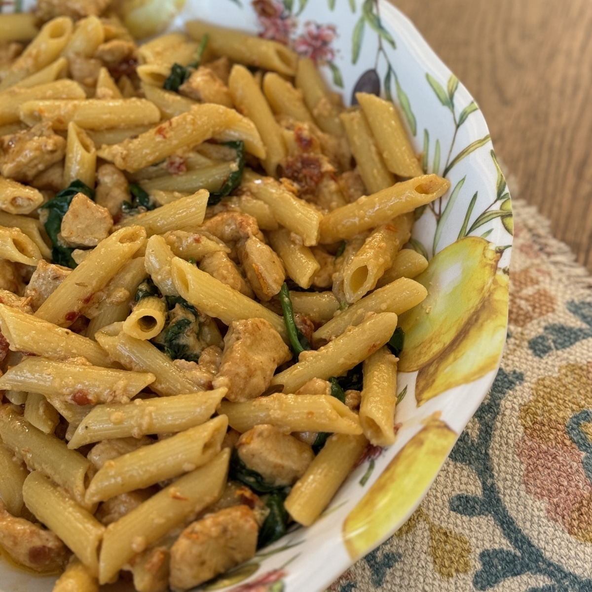 finished creamy chicken tuscan pasta in a serving dish
