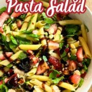 close up of the recipe in a bowl - text overlay says strawberry pasta salad